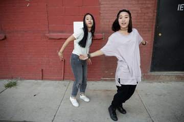 Young Asian woman in city dancing hip hop