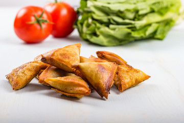 Gold and brown deep fried chicken samosas.