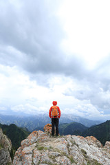  successful woman backpacker enjoy the view on mountain peak