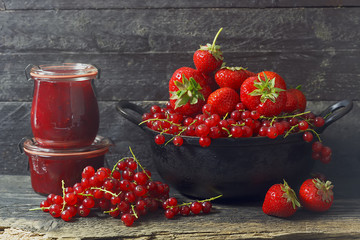  Marmelade im Glas mit frischen Beeren,  rustikaler Hintergrund