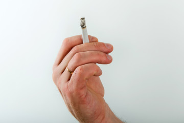 Young stylish man is smoking a cigarette. Smoking is dangerous to life. Selection of filter cigarettes or electronic.