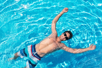 Positive man swimming in a pool