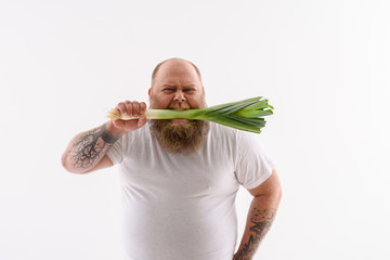 Bearded guy eating healthy vegetable
