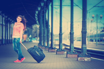 a girl on train station waits a train