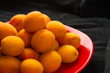 fresh apricots in red plate