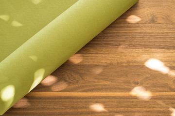 Yoga mat on a wooden background. Equipment for yoga. Concept healthy lifestyle. Lots of copyspace