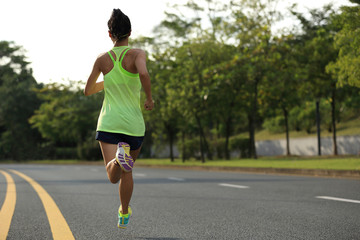 young fitness woman runner running on road
