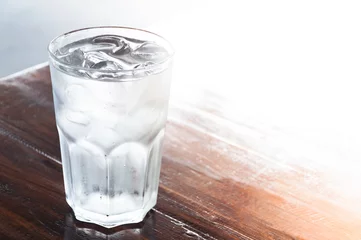 Foto op Plexiglas glas water met ijs op houten tafel, schoon water, drinkwater © rawintanpin