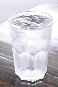 glass of water with ice on wooden table , clean water,drinking water