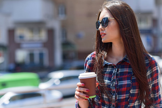 Pensive girl enjoying hot drink outdoors