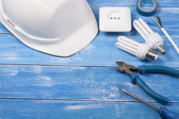 Set of electrical tool on wooden background. Accessories for engineering work, energy concept.