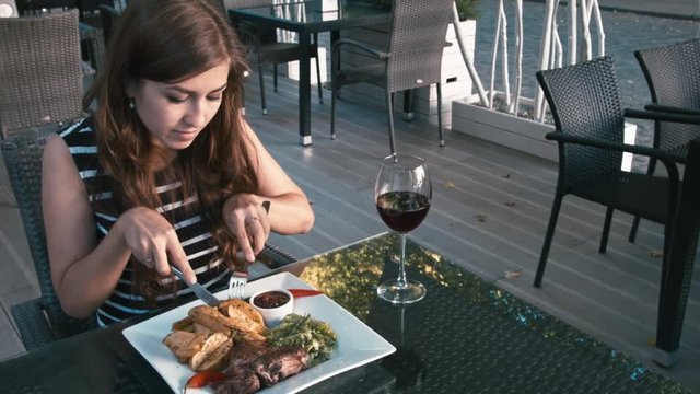Cute little girl eats and drinks wine