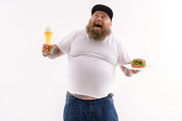 Man with a beer and sandwich in both hands