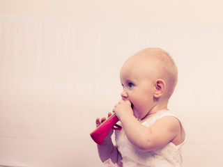 Baby girl biting shoe