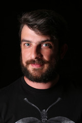 Bearded guy looking into the camera. Close.up. Black