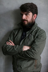 Obraz premium Bearded guy leaning on wall with crossed hands. Close.up. Black