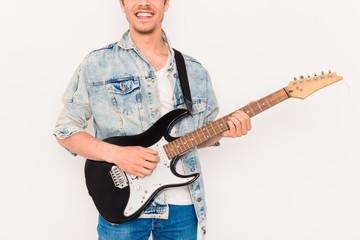 Close up of young rocker with beaming smile and electric guitar