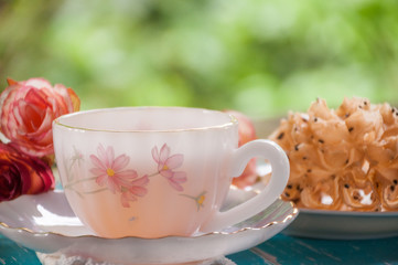 Hot tea with fried sweet pastry on wooden table