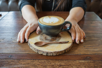 woman hand hot fresh coffee in white cup on wooden table spoon saucer rabbit print in coffee shop cappuccino coffee mocha coffee espresso coffee latte coffee