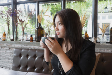 woman is sipping coffee at coffee time with wooden table and relax atmosphere