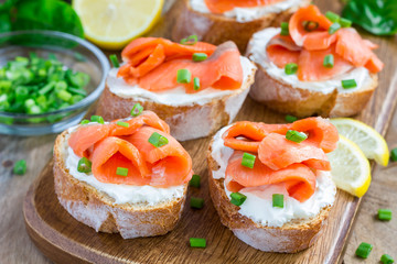 Sandwich with smoked salmon and cream cheese, wooden board, horizontal