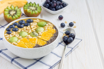 Breakfast smoothie bowl topped with berries, fruits, nuts and seeds