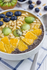 Breakfast smoothie bowl topped with berries, fruits, nuts and seeds