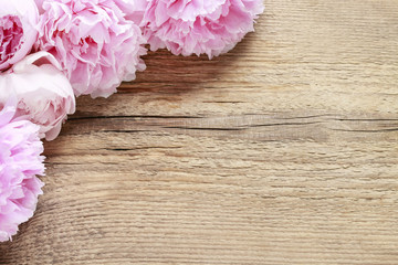 Stunning pink peonies on brown rustic wooden background