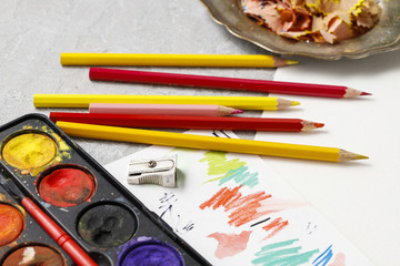 Naklejka premium Watercolor paint box and colorful crayons