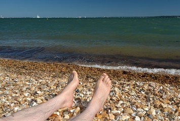 Pieds de vacancier sur la plage