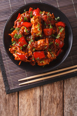 pork in sweet and sour sauce with peppers, carrots and onions. Vertical top view
