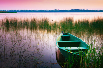 Obraz premium Rowing boat floating over the Lake Lasmiady waters. Masuria, Poland.