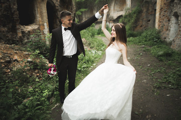 Beautiful fairytale newlywed couple hugging near old medieval castle