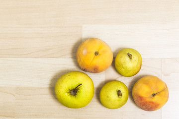 Apples and peaches zenital wooden background