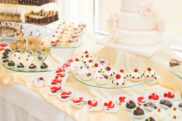 Naklejka premium Delicious and tasty dessert table with cupcakes shots at reception closeup