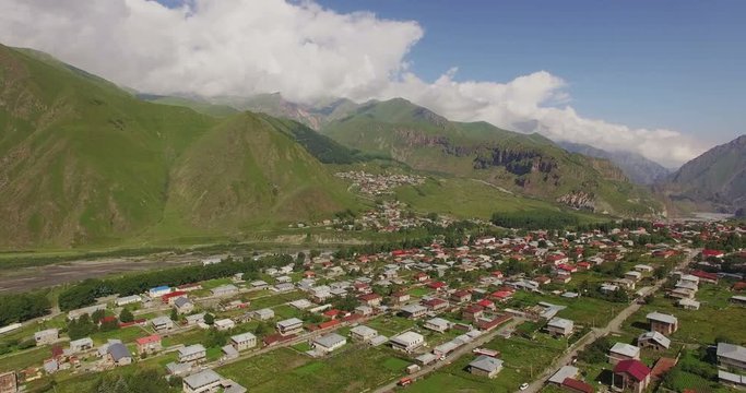 Stepantsminda, Kazbegi, GEORGIA July 27, 2016: Aerial view of small town Stepantsminda, Kazbegi near mountain Kazbek, Georgia. Shoot by drone 4k.