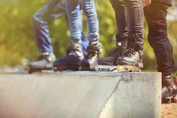 Aggressive inline rollerblader standing on ramp in skatepark