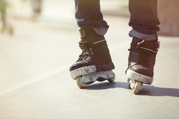 Feet of aggressive inline rollerblader on outdoor skatepark