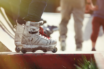 Aggressive inline rollerblader standing on ramp in skatepark