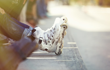 Roller blader sitting on a ledge in a skatepark. Aggressive inline skater in a skate park