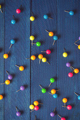 background of scattered colored round pins on wooden boards