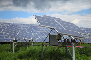 Solar panels used to generate electricity from sunlight against clouds and sky.