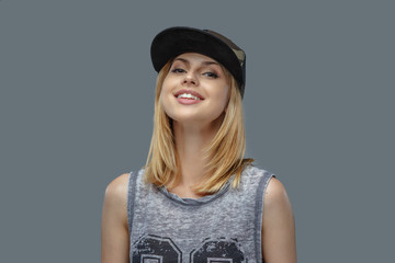 Portrait of positive blond female in baseball cap.