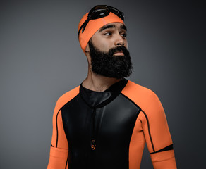Male in scuba diving mask and orange neopren diving suit.