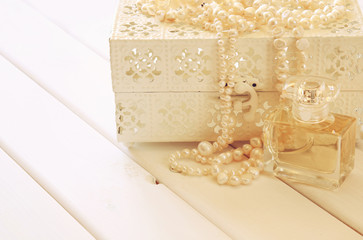 White pearls necklace and perfume bottle on toilette table