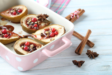 Baked pears with honey, walnuts and cranberries on white wooden