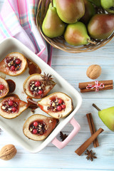 Baked pears with honey, walnuts and cranberries on white wooden