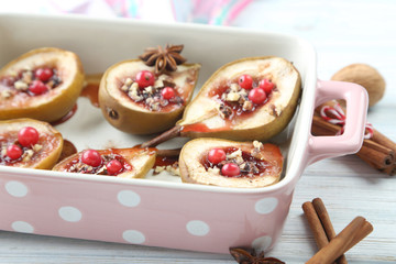 Baked pears with honey, walnuts and cranberries on white wooden