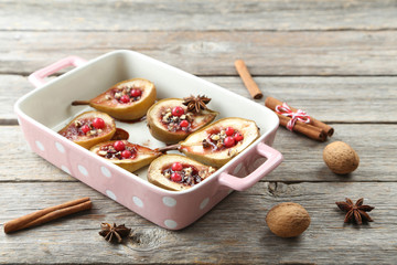 Baked pears with honey, walnuts and cranberries on grey wooden t