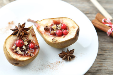 Baked pears with honey, walnuts and cranberries on grey wooden t